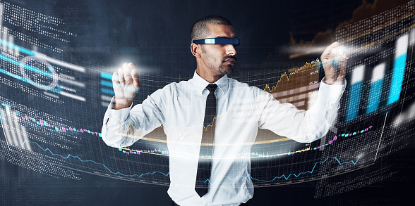 Studio shot of a young businessman connecting to a digital interface against a dark background