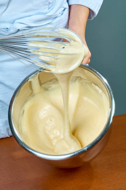 istock chef whips yellow cream in a bowl by hand for making cheesecakes 654220918
