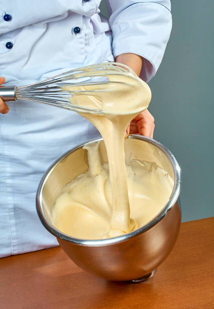 istock chef whips yellow cream in a bowl by hand for making cheesecakes 654221040