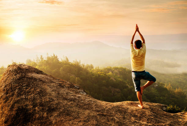 istock Asian man doing yoga on mountain peak 654234538