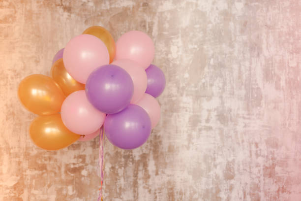 istock Bright balloons bunch against a textured wall 654238734