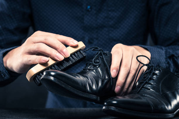 istock Hand brushing black leather shoes men 654244198
