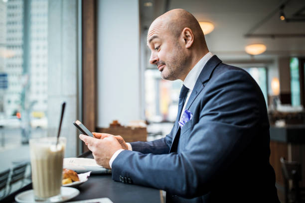 istock Mature businessman at coffee shop using smart phone 654247650