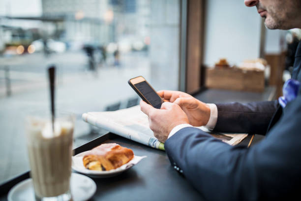 istock Mature businessman at cafe using cell phone 654247674