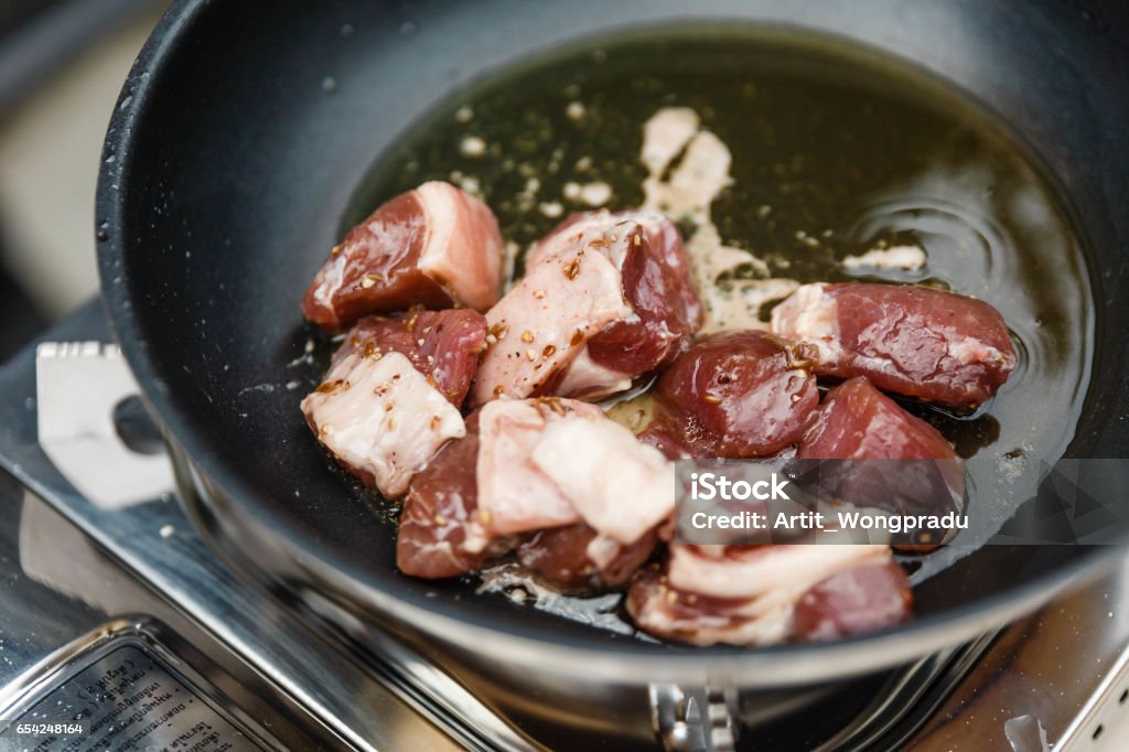 Chef Fried Marinated Diced Raw Beef in Pan with Rosemary Oil Cube Shape Stock Photo