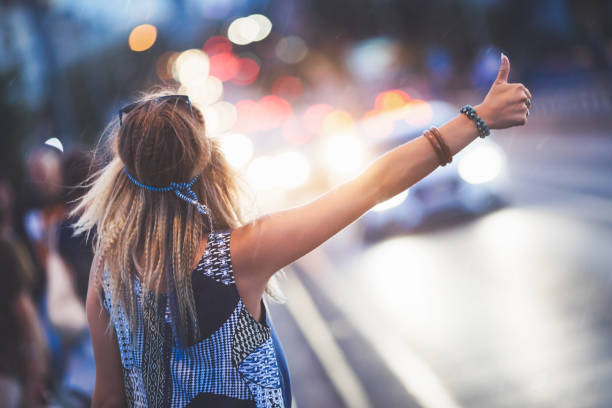 istock Beautiful woman hailing a cab at night while raining 654252254