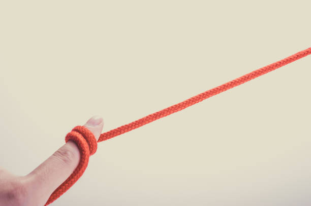 istock Fingers of humans with red thong 654252976