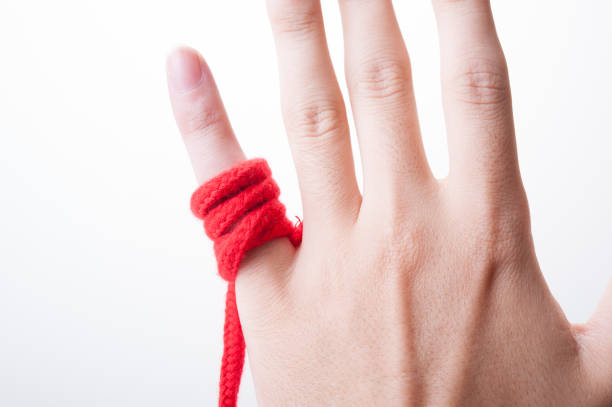 istock Fingers of humans with red thong 654252992