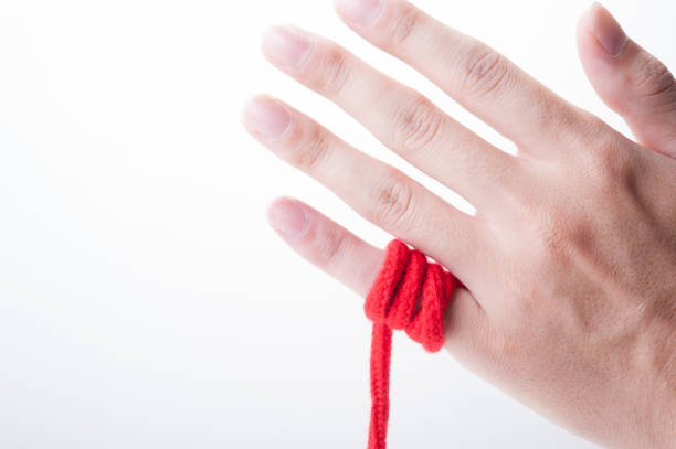 istock Fingers of humans with red thong 654252998