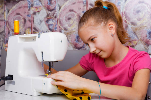 istock Girl learns to sew 654258516
