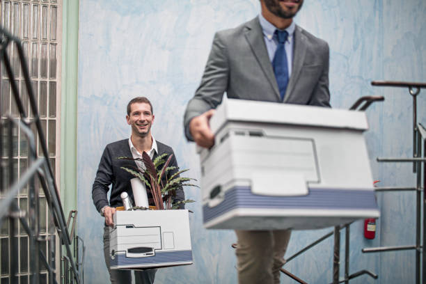 Businessmen with belongings on staircase in office