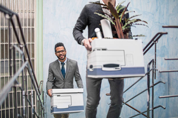 istock Smiling businessmen with belongings on staircase 654258666