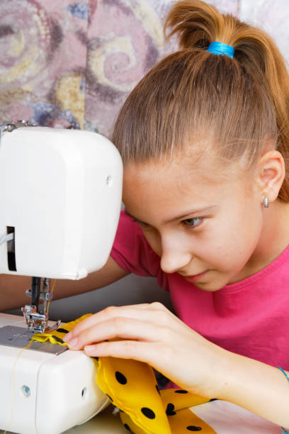istock Girl learns to sew 654258812