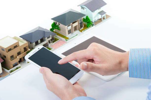 istock Hand with smart phones and miniature House 654259306