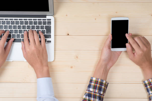 istock Hand of man using a laptop and a smart phone 654264490