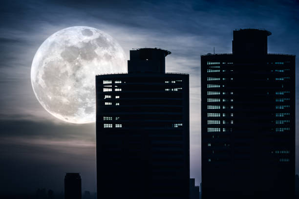 istock Silhouettes of two skyscrapers construction with supermoon. 654280158