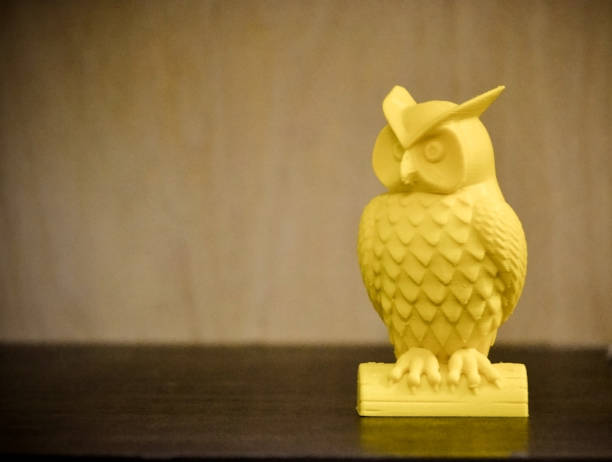 istock 3D printer printing yellow figure close-up 654285216