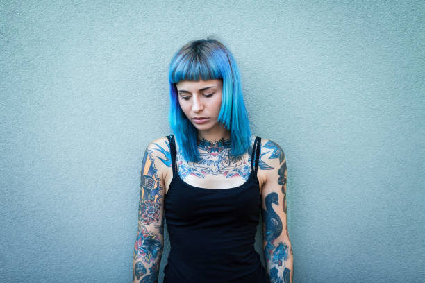 junge tätowierte frauen mit blauem haar - alternativer lebensstil stock-fotos und bilder