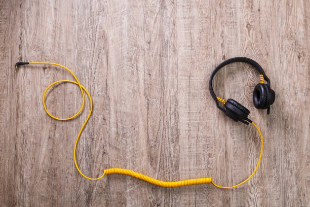 istock Headphones with yellow cable. Wooden background. 654288142