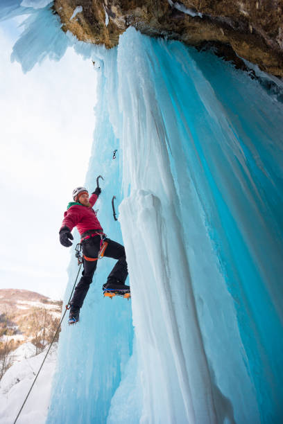 istock Male ice climber holding on a single ice axe 654289348