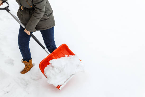 donna con pala che pulisce la neve invernale. - paletta foto e immagini stock