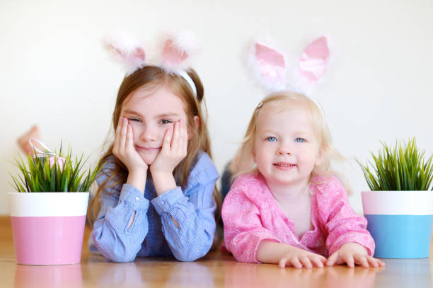 istock Two adorable little sisters wearing bunny ears on Easter 654324002