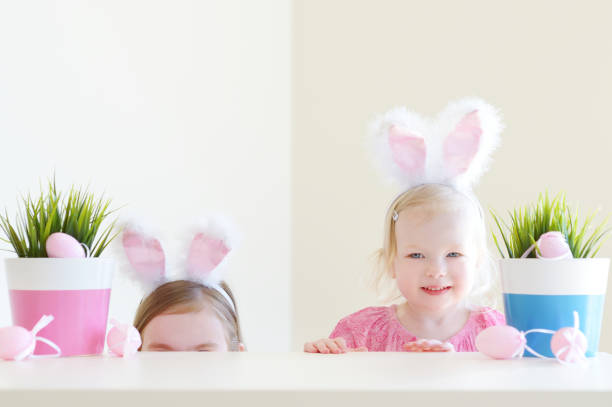istock Two adorable sisters wearing bunny ears on Easter day 654324016