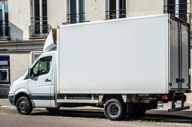 istock Blank white van or truck with copy space parked in a street 654324078