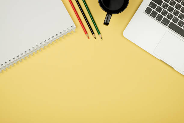 istock Modern office desk table with laptop, blank notebook page for input the text in the middle and other supplies. Top view, flat lay 654324158