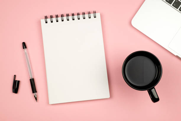 istock Modern office desk table with laptop, blank notebook page for input the text in the middle and other supplies. Top view, flat lay 654324190