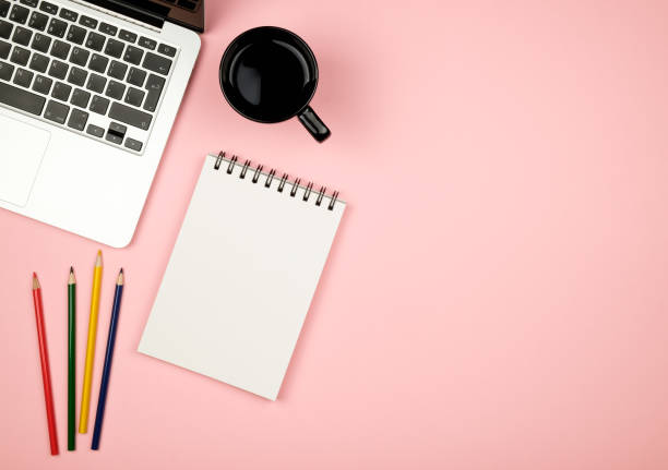 istock Modern office desk table with laptop, blank notebook page for input the text in the middle and other supplies. Top view, flat lay 654324192