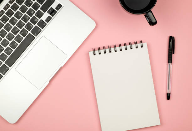 istock Modern office desk table with laptop, blank notebook page for input the text in the middle and other supplies. Top view, flat lay 654324204