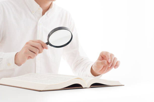 istock Japanese men have read the book with a magnifying glass 654327112
