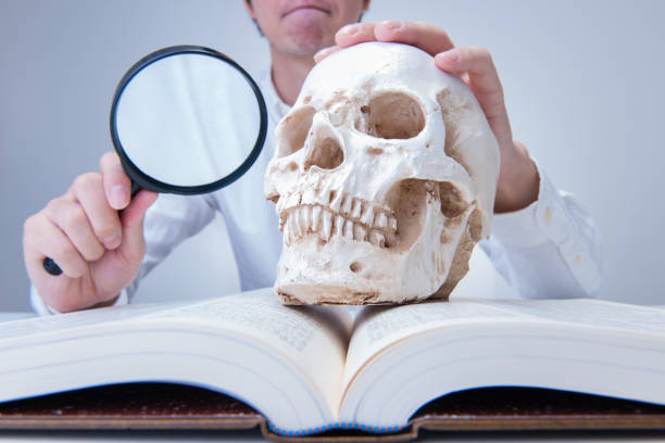 Japanese man with a human skull and magnifying glass