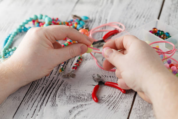 istock man hand making earrings of polymer clay. Hobby, handicraft background 654332354