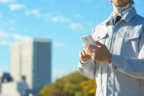 istock Japanese man wearing work clothes with a Smartphone 654337160