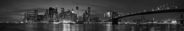 New York city with Brooklyn Bridge, iconic skyline panorama at night in black and white New York city with Brooklyn Bridge, iconic skyline panorama at night in black and white, high detailed liberty tower stock pictures, royalty-free photos & images