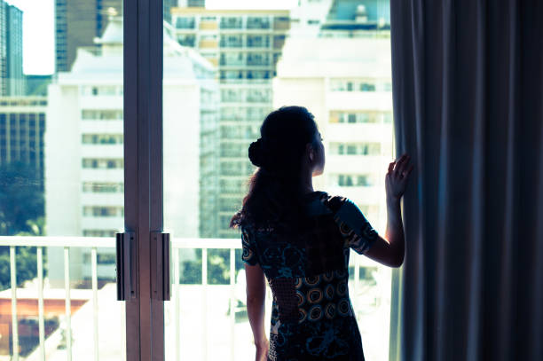 istock Woman looking out of a window 654353050