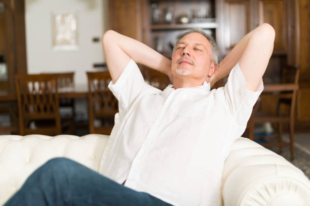 istock Smiling man relaxing on the couch 654353694