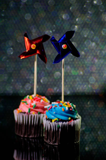 istock Party Cupcake with candy sparkler, windmill pinwheels, bokeh light background 654357084