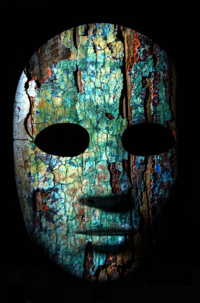 Textured mask with cracked rough wood  painted surface, neutral expression on dark background.