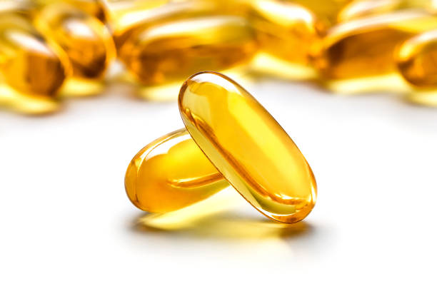 dwie kapsułki omega 3 wyizolowane na białym tle - fish oil vitamin pill cod liver oil nutritional supplement zdjęcia i obrazy z banku zdjęć