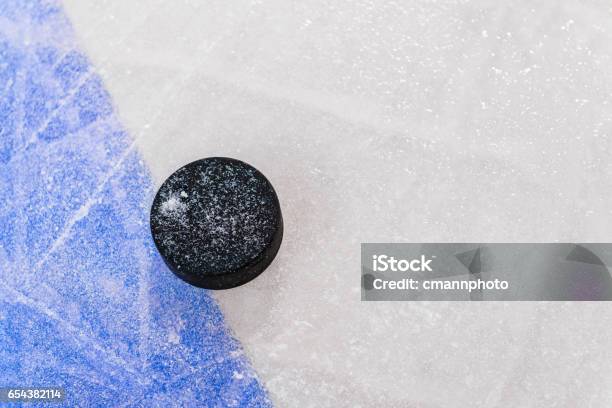 Ice Hockey Puck Next To Blue Line In Rink Stock Photo - Download Image Now - Hockey, Hockey Puck, Single Line