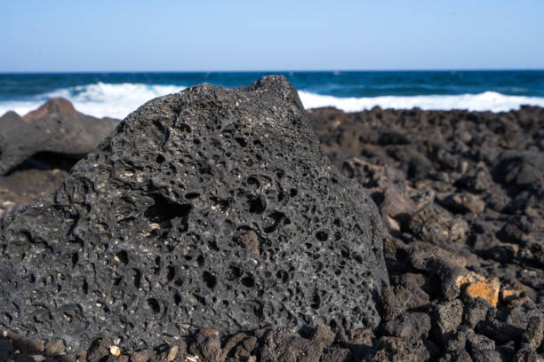The structure of the black volcanic stone on the beach of the Atlantic Ocean