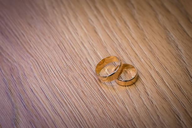 istock wedding rings on a wooden table 654395062