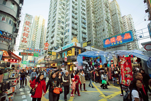 Hong Kong - February 9, 2016: Crowd of people walking on busy market street with bright showcases of shops and malls on February 9, 2016. There are 1,223 skyscrapers in Hong Kong.
