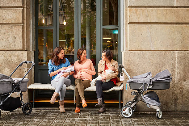 expectant and friends with babies sitting on bench - friendship cafe social gathering talking zdjęcia i obrazy z banku zdjęć