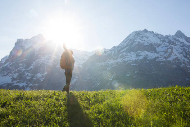 istock Female hiker stretches into sunlight, mountains 654401815