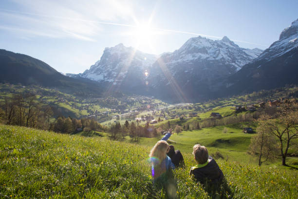 istock Couple relax in meadow above village, mountains 654401831