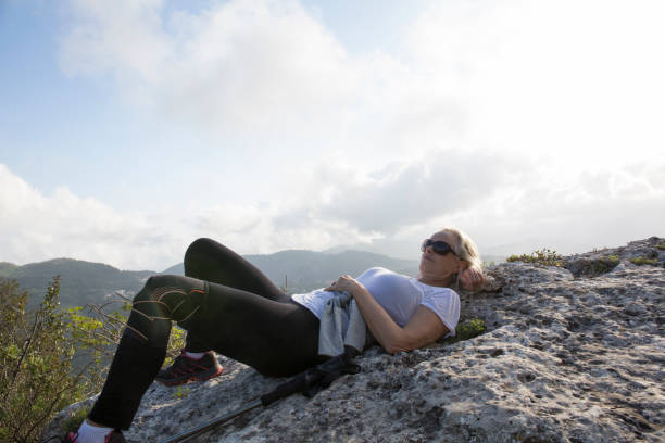 istock Female hiker relaxes on stone shelf in hills 654401835